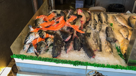 Washington D.C., USA, May 25, 2025. Freshly caught fish including salmon and catfish are arranged on ice inside a seafood stall at the wharf.のeditorial素材