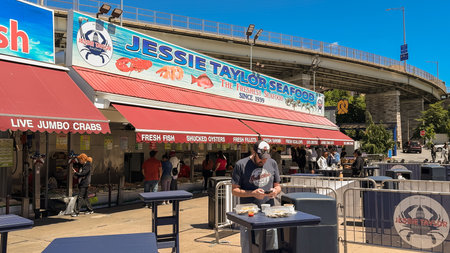 Washington D.C., USA, May 25, 2025. A customer enjoys food on a patio table as others line up...