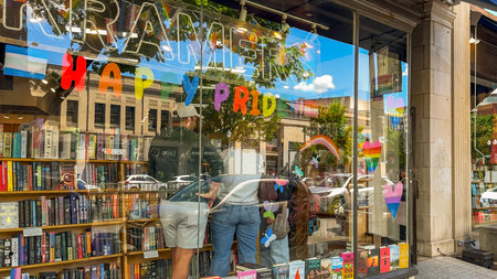 Washington D.C. USA - May 24, 2025. People browse inside Kramers bookstore where rainbow hearts and a pride message decorate the front windows.のeditorial素材
