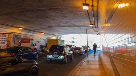 Washington D.C., USA, May 25, 2025. A man walks along the sidewalk as cars queue in traffic exiting...