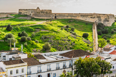 Medieval castle of Castro Marim rising over lush hill and traditional buildings in Algarve, Portugal.の写真素材