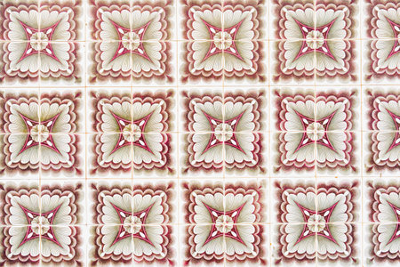 Seamless pink and cream ornamental pattern on square ceramic tiles.