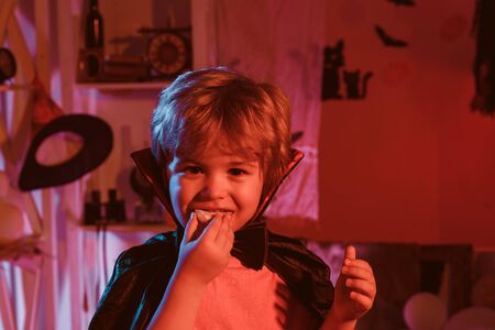 The little dracula is eating Halloween cookies. Halloween treats and sweets for children. Happy Halloween. Childrens party.の写真素材