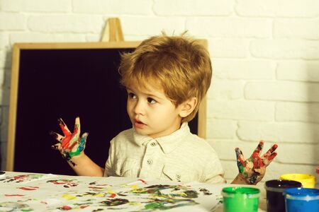Art therapy. Drawing as a treatment for frustration. The boy draws his fingers. Child with paints.の写真素材