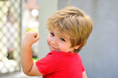 Sports for children. Strong handsome boy shows his muscles. Toddler after training workout. Healthy...