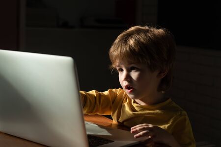 Child at home using a laptop for watching cartoons. Interesting information on the Internet for children. Internet Security. Cyber threat.の写真素材
