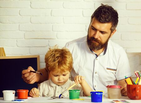 Family happy time. Art with father. Dad and son painting together. Time to school. Art education.の写真素材