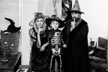 Family secret. A terrible holiday. Family in Halloween costumes. Skeleton, witch and wizard. Black...