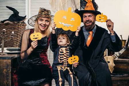 Family friends posing for the camera in halloween costumes. Happy family celebrating Halloween. Funny kids and parents in carnival costumes. Pumpkin icons.の写真素材