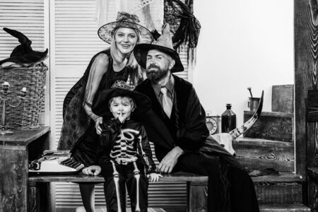 Halloween Family Photos. Skeleton posing with parents. Halloween party at home. Witch hat. Holiday halloween with funny carnival costumes.の写真素材