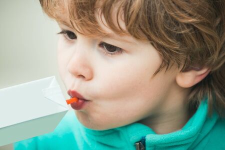 Juice from a bag. Plastic straws for drinks. Thirst. Beautiful boy drinks juice.