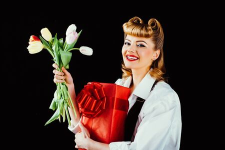 Happy birthday. Happy woman with present and flower. Girl with tulips and red surprise box on black...