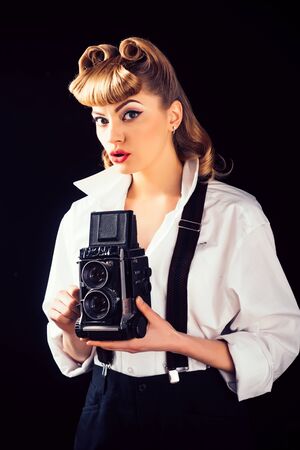 Retro vintage concept. Beautiful woman holding a camera. Old style. The best moments of life on film.の写真素材
