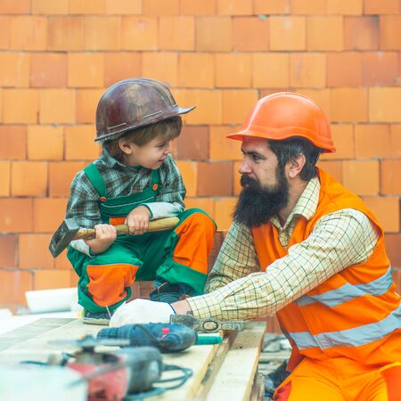 Father and son. Builders. Tools at a construction site. Hard work. Salary. Family business....
