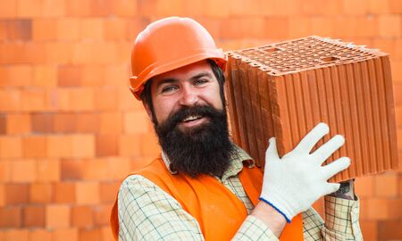 Business, industry, technology. Builder concept. Young construction workers in hard hats on orange...