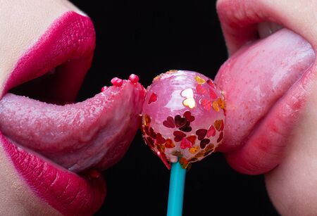 Sweet kiss lips. Lesbian love concept. Lollipop between female lips. Erotic dessert. Passion between...