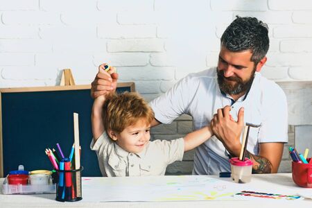 Happy family. The boy and his father are playing in the children room. Funny homework to prepare for school. Preschooler and his father enjoy the day. Bearded father and cute son.の写真素材