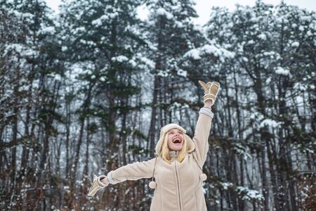 Winter happy girl. Young woman with a smile on a background of a winter forest. Happy vacation in nature. Winter activities.の写真素材
