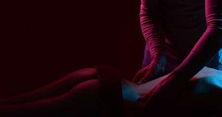 Back massage, spa center. Sexy massage, man hands. Sexy couple with slim body, beautiful spa salon. Intimate atmosphere.の写真素材
