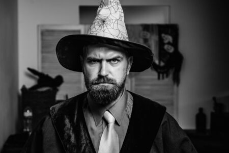 Handsome man in a magic hat with a spider web. Serious man as an animator for childrens exciting...