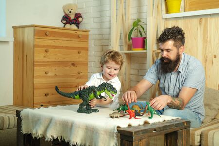 Family game. Child, father and dinosaur. Childrens hobbies. Boy and dad.の写真素材