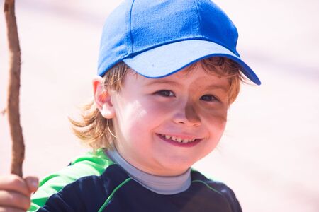 The dirty face of happy child. Happy game in the swamp on the street. Mud on childrens face. Boy war...