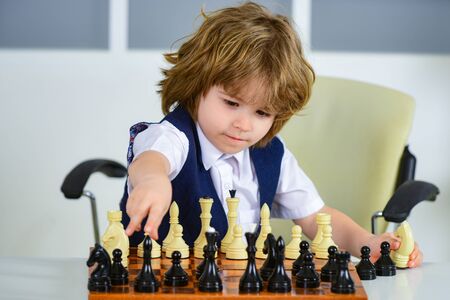Businessman play with chess game. Concept of business strategy and tactic. A child as a small businessman with strategic thinking. Chess for children.の写真素材