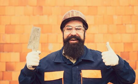 Happy builder worker. Cheerful man with a smile at a construction site. New construction for happy people.の写真素材