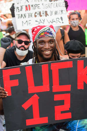 Miami Downtown, FL, USA - MAY 31, 2020: Happy black man with poster Fuck 12. Protest agains US police.のeditorial素材