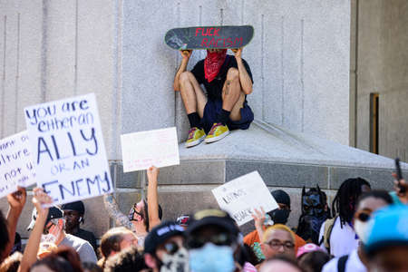 Miami Downtown, FL, USA - MAY 31, 2020: White man against racism. Fuck racism - the inscriptions on the skateboard.のeditorial素材