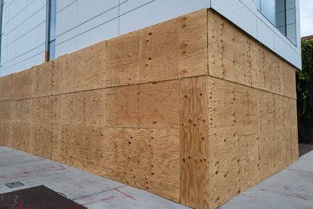 Exterior-grade plywood, at minimum. Hurricane plywood installation. Boarding up windows with plywood prevent dangerous debris from smashing into home during a tropical storm with violent winds.の写真素材