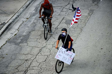 Miami Downtown, FL, USA - JUNE 12, 2020: Black Lives Matter. Black man with Amedican flag and poster. Demonstrations Against Racism in the USAのeditorial素材