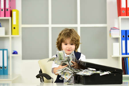Money. The boy is holding dollars in his hands. Finance and business. Education.の写真素材