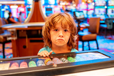 Sad boy in casino. Gambling. Entertainment and leisure. Casino chips. Child.の写真素材