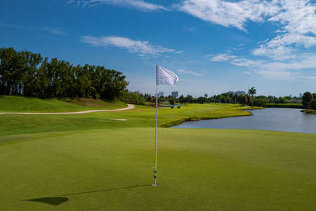 Golf course with bunker, lake and green. Golf course with a rich green turf beautiful scenery.の写真素材