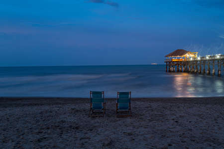 Romantic evening by the ocean. Two chairs on the shore.の写真素材