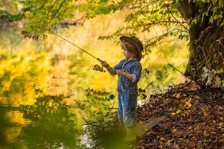 Fishing and forest lake. Autumn and nature. Outdoor vacation. Entertainment instead of gadgets.の写真素材