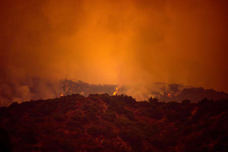 Orange sky over the mountains of California. Fires near Los Angeles. Smoke pollution in US air.の写真素材