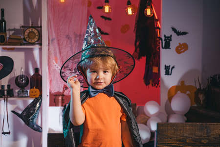 A boy dressed as a wizard. Lonely child celebrating Halloween at home on a picture. Coronavirus covid quarantine in autumn 2020.の写真素材