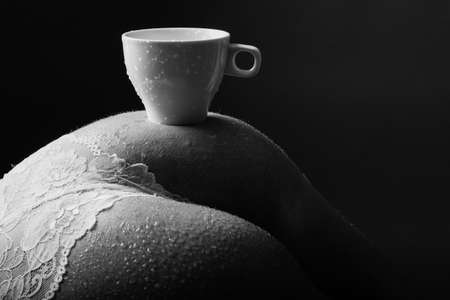 Coffee time. Erotic wife. A cup of coffee on the buttocks in white underwear.の写真素材