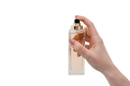 Bottle of perfume in female hand isolated on white background. young woman holding bottle of...
