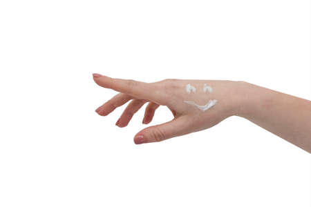 A smiley face drawn on the hand. Hand skin care. Closeup of beautiful woman hands with manicure on nails. Taking good care of yourself. Preventing skin infections. Cream for hands and treatment.の写真素材