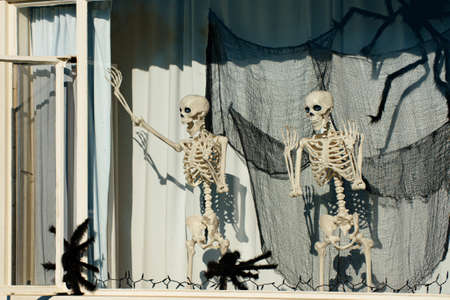 Skeletons in the window. Halloween scenery. Terrible holiday at home. Halloween in the USA. Traditions and house decor. Terrible creatures.の写真素材