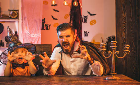 Scary. Halloween tricks. The family is preparing for the autumn holiday. Father and son have fun together. Costumes wizards for a party.の写真素材