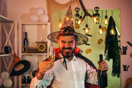 Happy man celebrates Halloween with sparkling wine.の写真素材