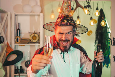 Halloween mood. Adult fun. Happy man celebrates Halloween with sparkling wine.の写真素材