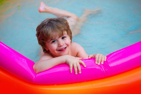 Happy kid in the pool. Summer holiday at home.の写真素材