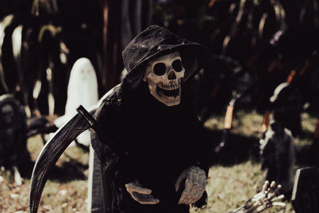 Black death with a scythe in the cemetery. Scenery for Halloween in October. Decoration in the yard.の写真素材