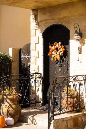 House with an autumn wreath on the front door. Scenery for Halloween in October. Decoration in the yard.の写真素材