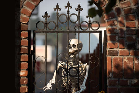 Skeleton in prison behind bars. Scenery for Halloween in October. Decoration in the yard.の写真素材